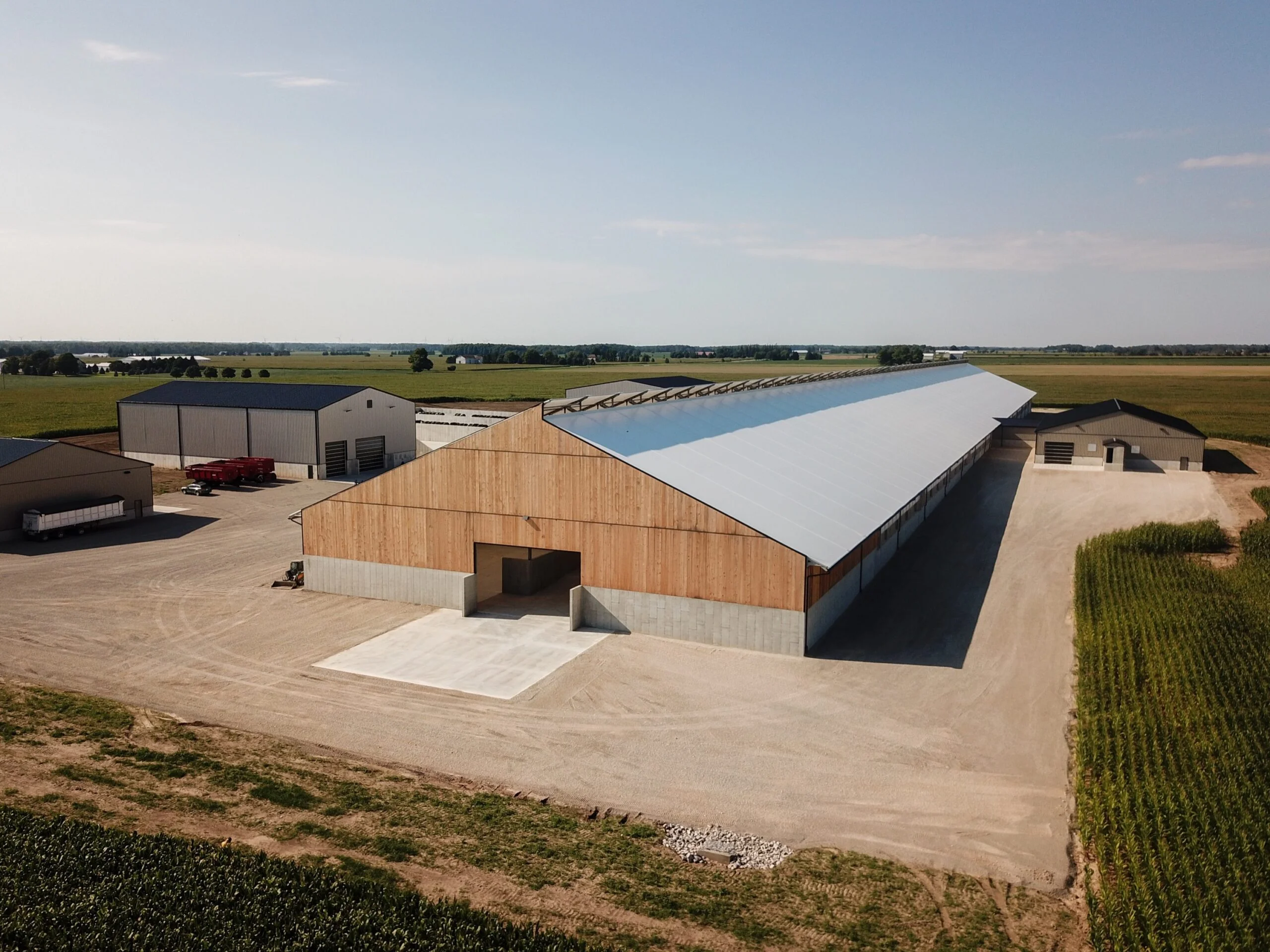 Aerial view of a large Britespan Epic Series gable-style fabric building with timber sidewalls on a beef barn