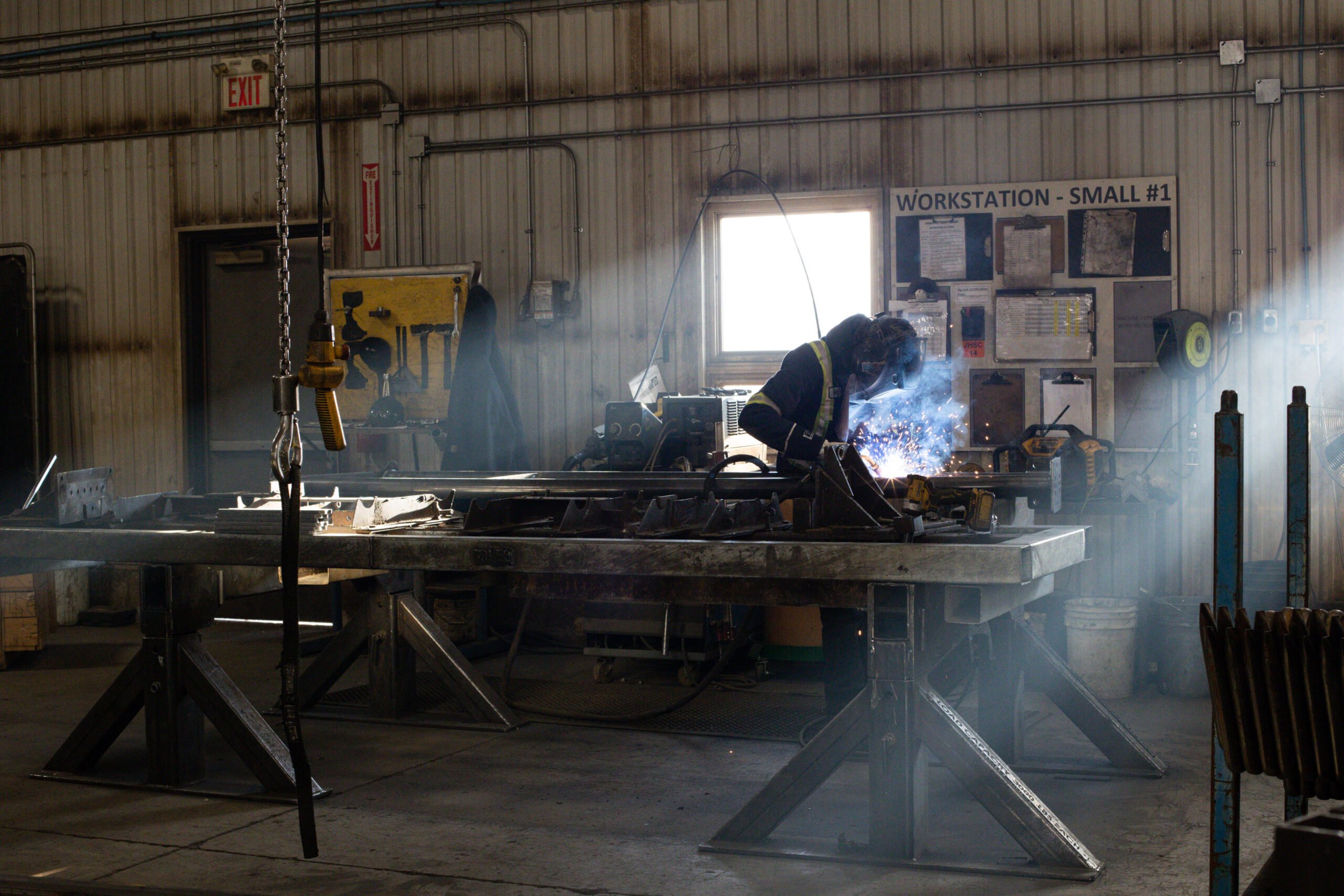- Britespan Interior of manufacturing warehouse steel fabric building with welder in window sunlight welding steel in the darkly lit building