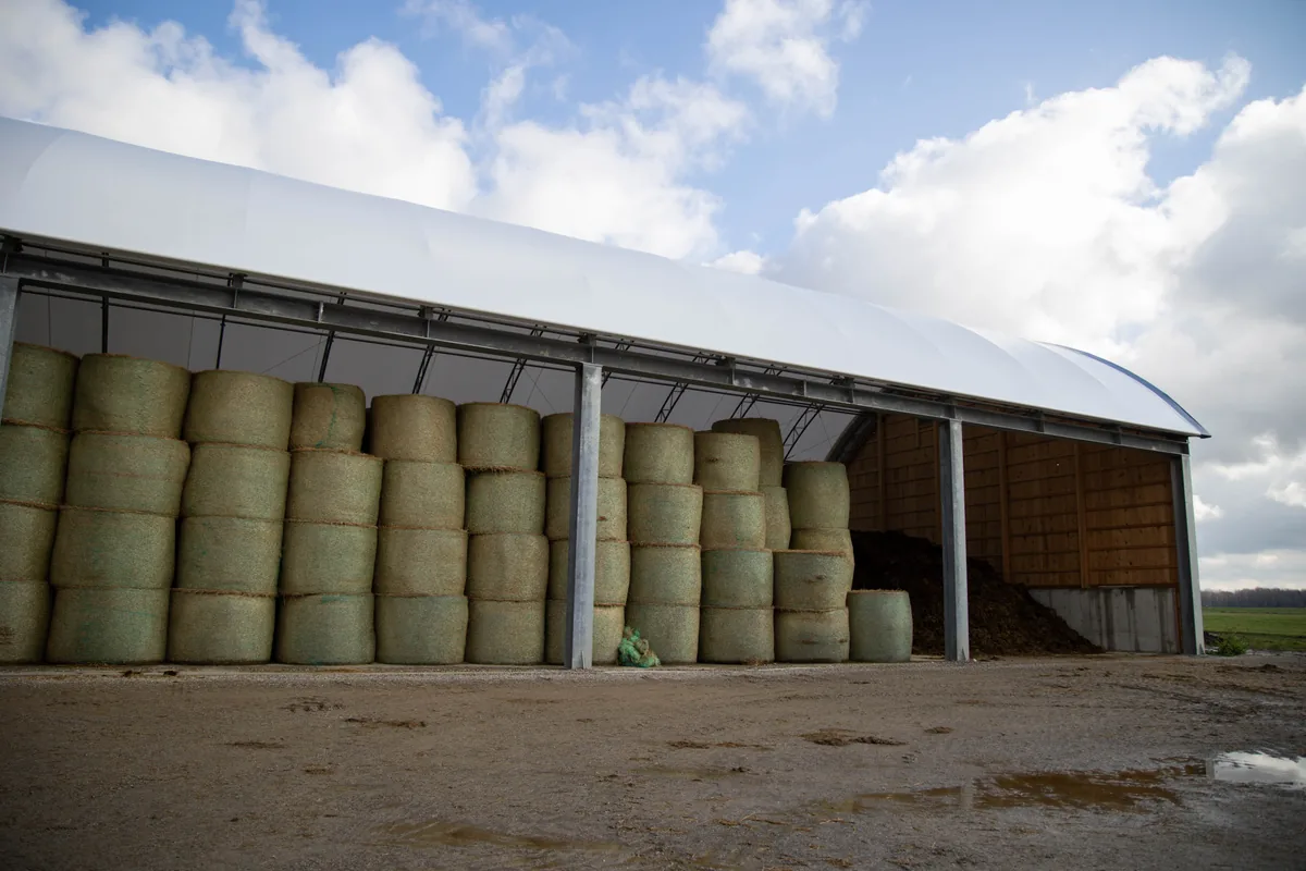 hay-storage-building-round-bales-stacked - Britespan Round bales stacked to full height inside a fabric hay storage building with an open end